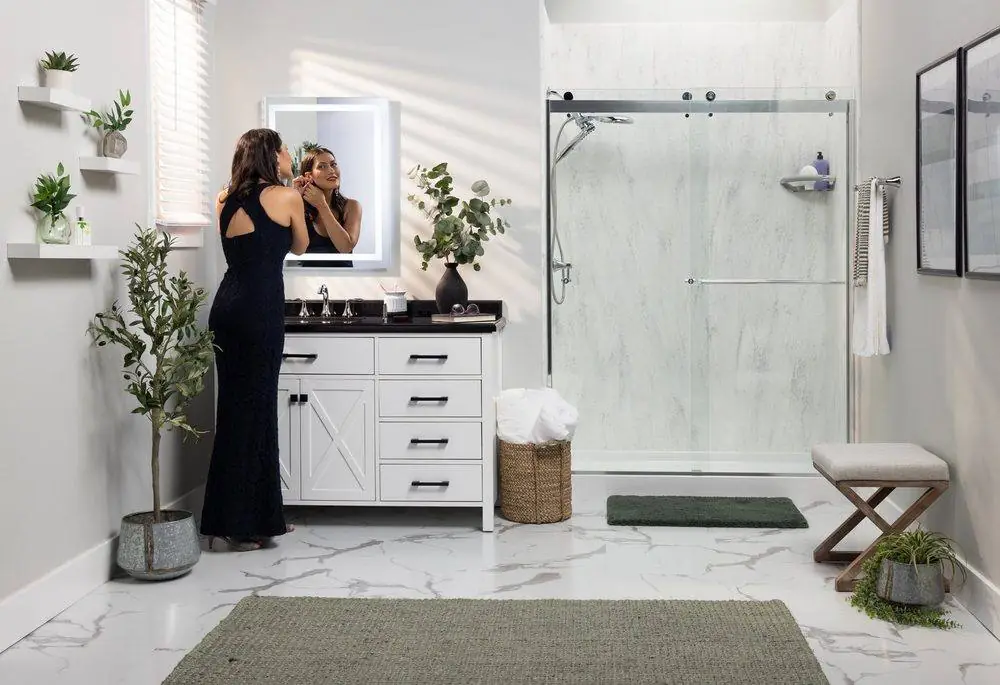 Woman getting ready in a bright bathroom with a new Luxury Bath glass shower