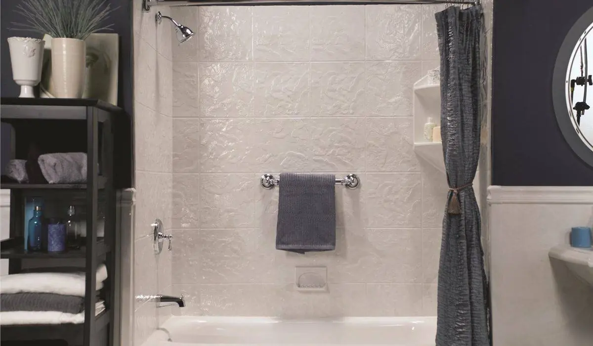 White replacement bathtub with a textured white wall surround, a chrome towel bar and a gray curtain