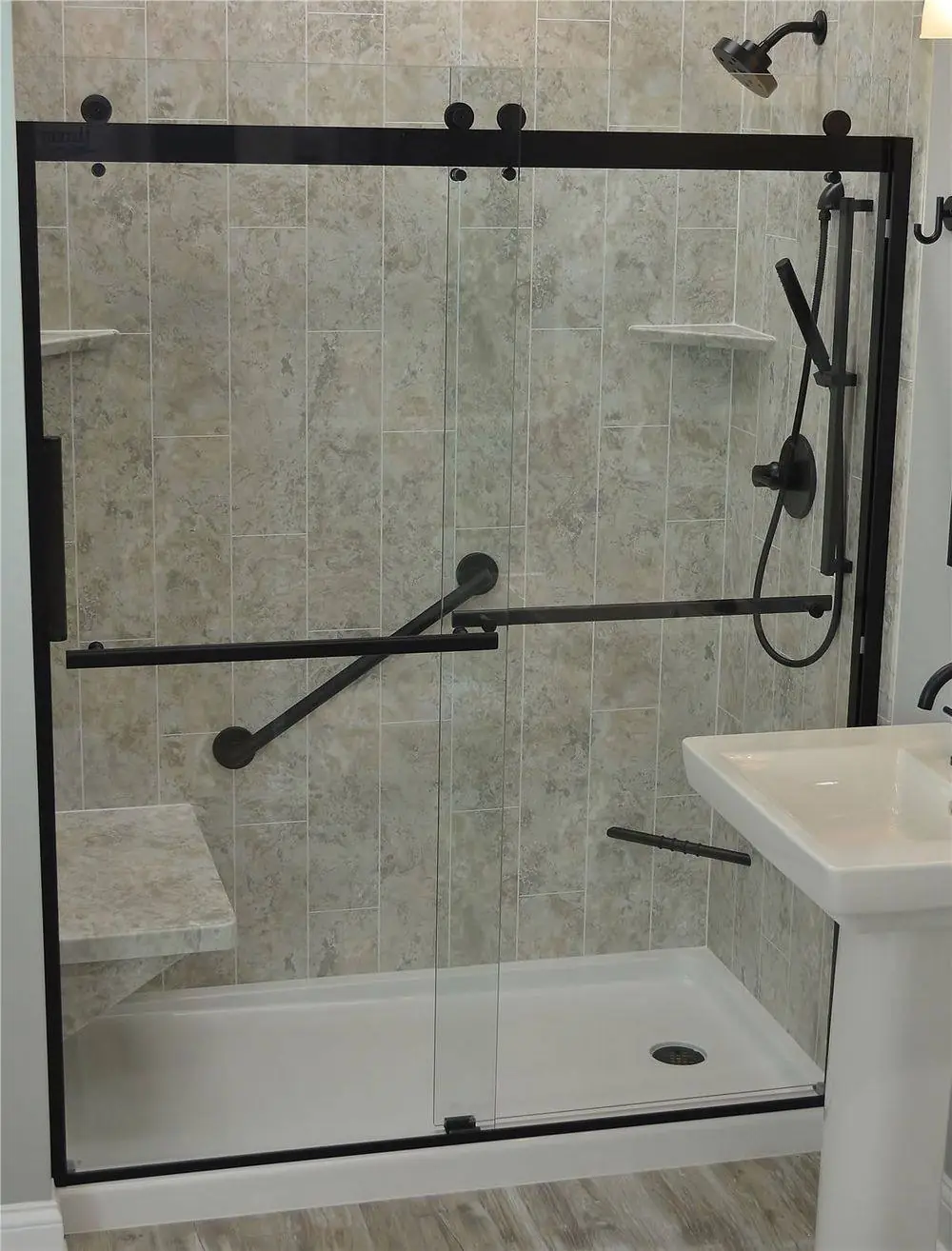 Walk-in shower with a marble look wall and a brushed gold shelf