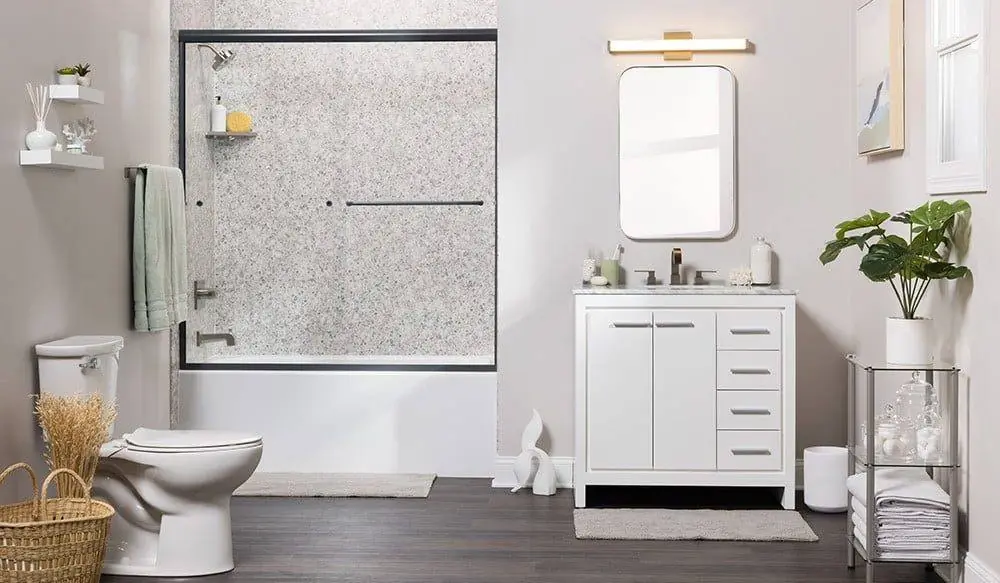 Tub with gray herringbone marble look walls, chrome fixtures and a gray curtain