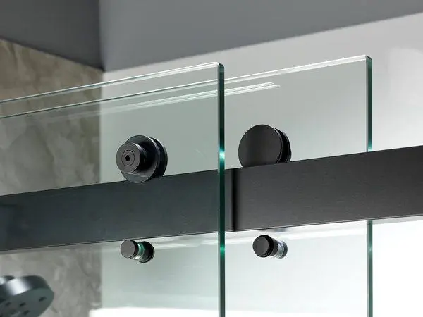 Close-up of a glass shower door with matte black hardware