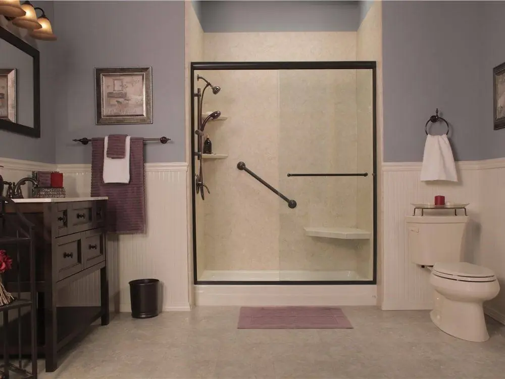 Shower with a framed glass door and a grab bar beside a wood vanity