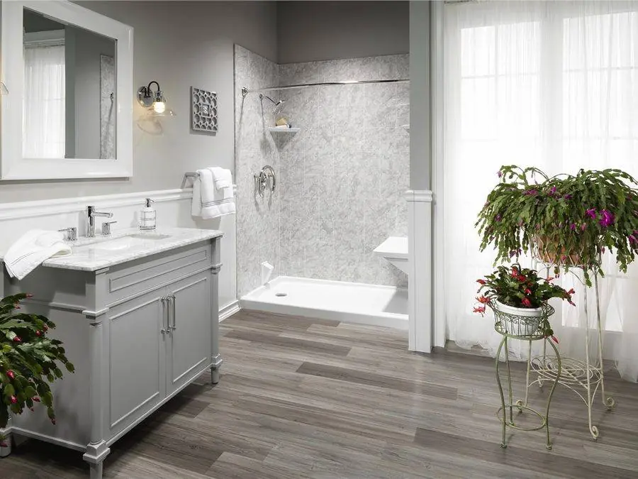 Bright walk-in shower with white panel walls beside a gray vanity