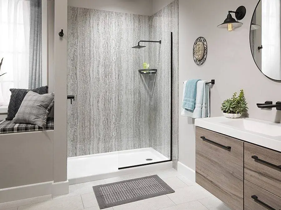 Walk-in shower with striated gray stone look walls and a black framed door