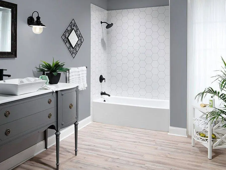 Tub and shower with patterned tile look walls and a gray vanity