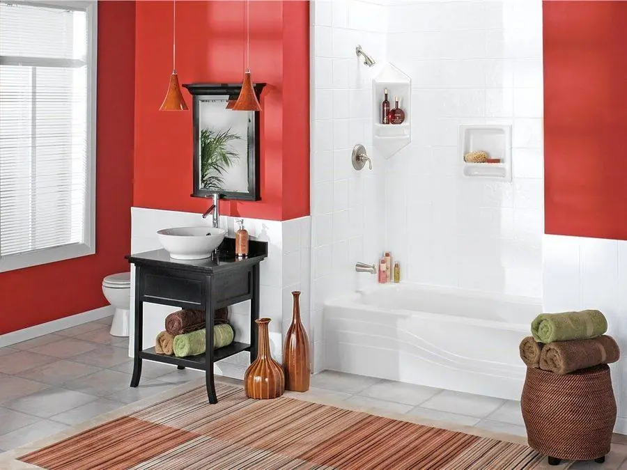 White bathtub and shower walls against a red accent wall