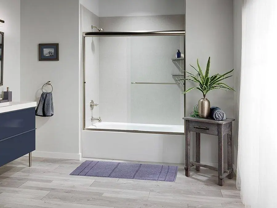 Bathtub with a sliding glass door and a navy vanity